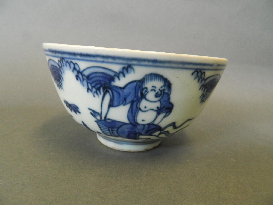 A Chinese blue and white porcelain rice bowl decorated: A Chinese blue and white porcelain rice bowl decorated with figures relaxing in a garden, 6 character mark to base, 4½" diameter