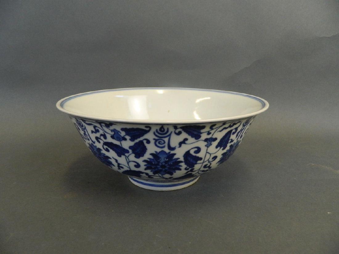 A Chinese blue and white porcelain bowl with scrolling: A Chinese blue and white porcelain bowl with scrolling lotus flower and character decoration, 6 character mark to base, 8½" diameter