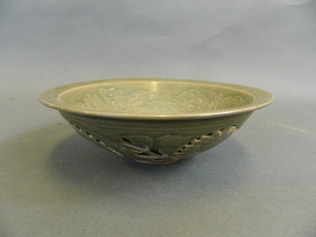 A Chinese Song style green glazed bowl with incised: A Chinese Song style green glazed bowl with incised stork and reticulated floral decoration, 7" diameter