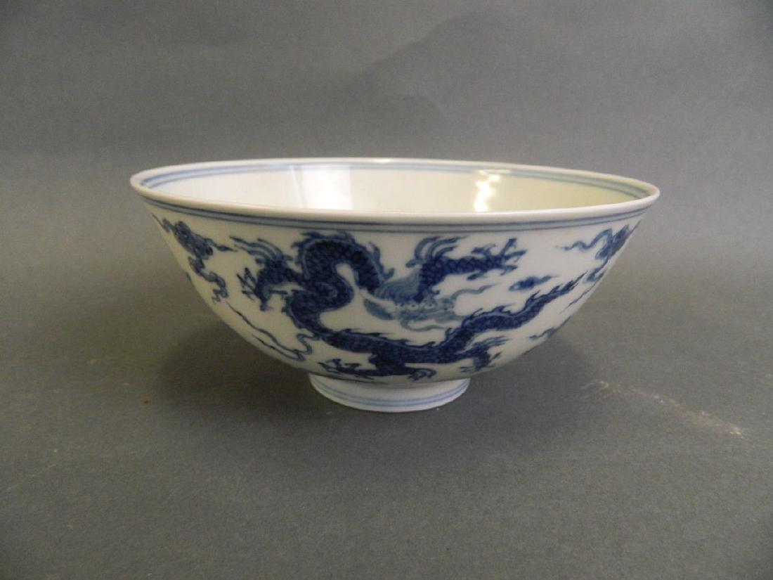 A Chinese blue and white porcelain rice bowl with: A Chinese blue and white porcelain rice bowl with dragon decoration, 6 character mark to base, 5½" diameter