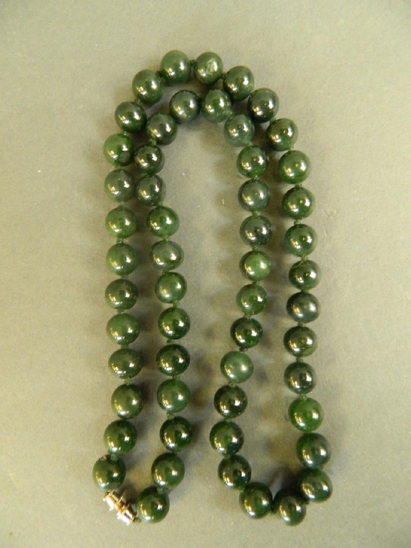 A string of jade beads, 23" long: A string of jade beads, 23" long