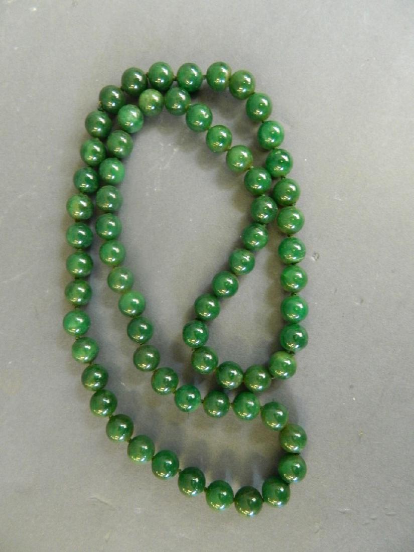 A string of green jade beads, 33" long: A string of green jade beads, 33" long