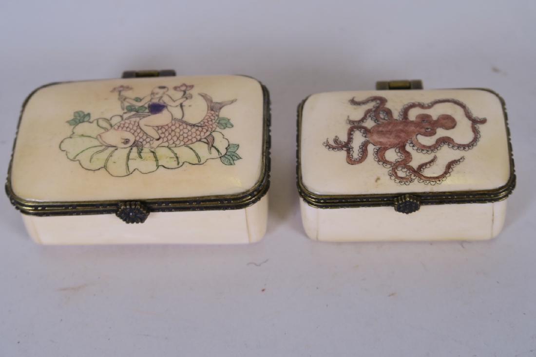 A bone patch box, the lid painted with a child riding a: A bone patch box, the lid painted with a child riding a dolphin, together with another smaller painted with an octopus, 2½" x 1½" x 1"
