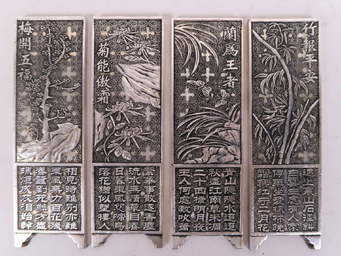 A set of four Chinese white metal scroll weights in the: A set of four Chinese white metal scroll weights in the form of screen panels, decorated with bamboo and calligraphy, 6" long