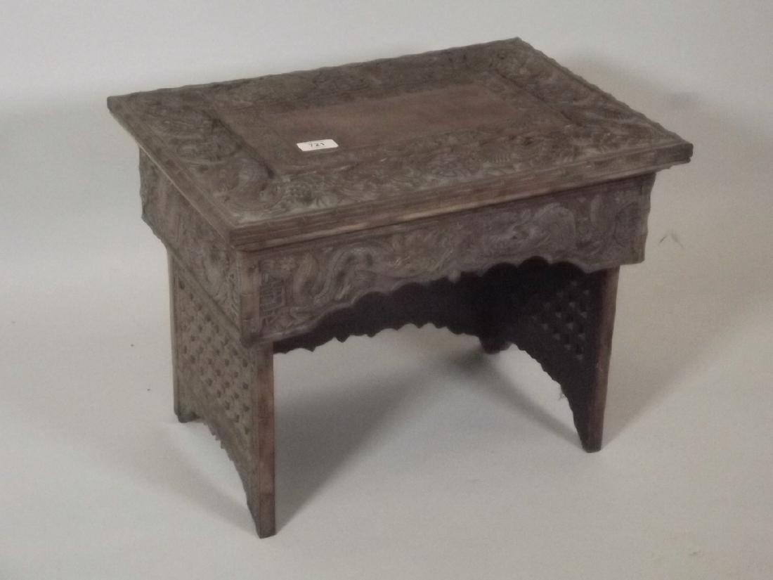 A C19th Chinese hardwood altar carved with dragons and: A C19th Chinese hardwood altar carved with dragons and symbols, on pierced end supports, 19" x 13" x 14"