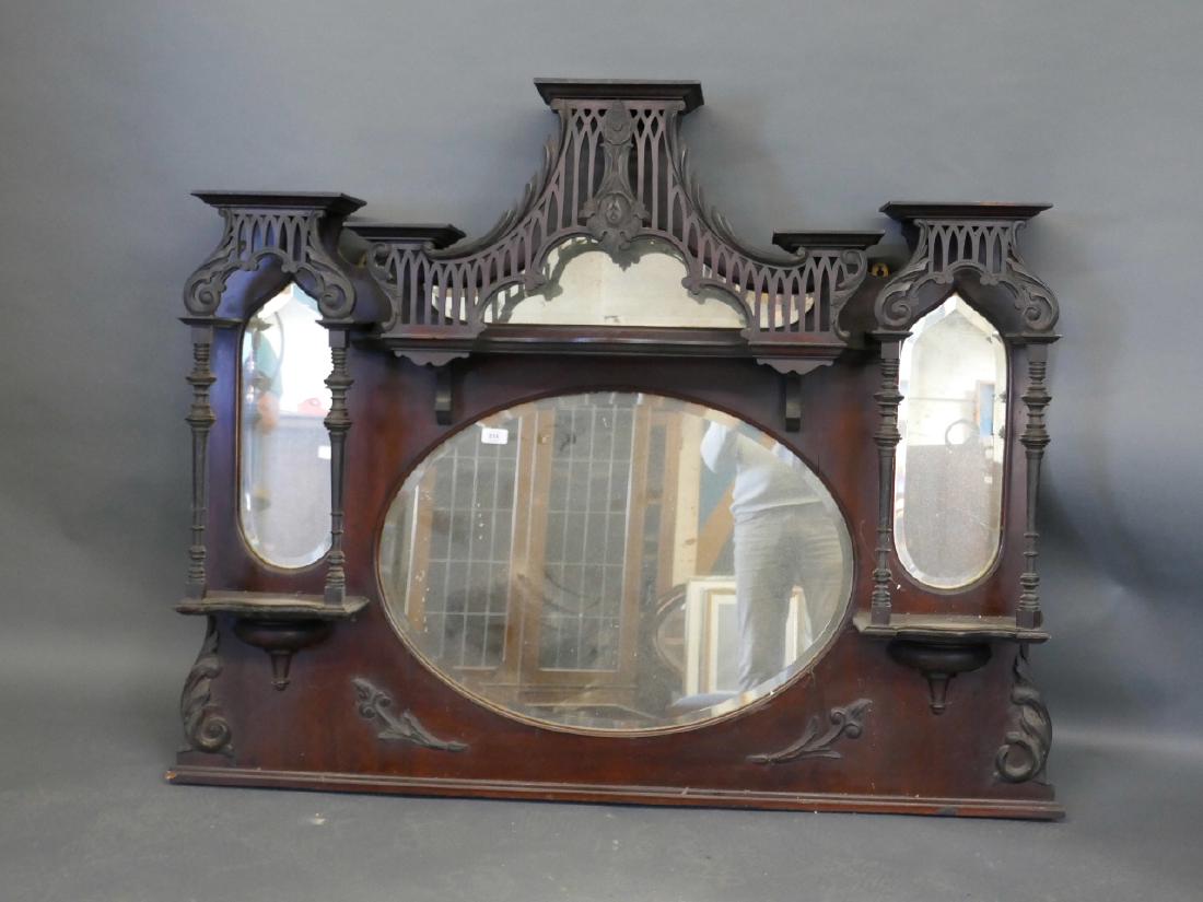 A C19th overmantle mirror with pierced Gothic style top: A C19th overmantle mirror with pierced Gothic style top over four shaped mirror glasses and turned columns, 44" high x 51" wide