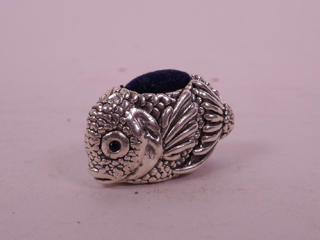 A silver pin cushion in the form of a fish, 1 1/2" long: A silver pin cushion in the form of a fish, 1 1/2" long