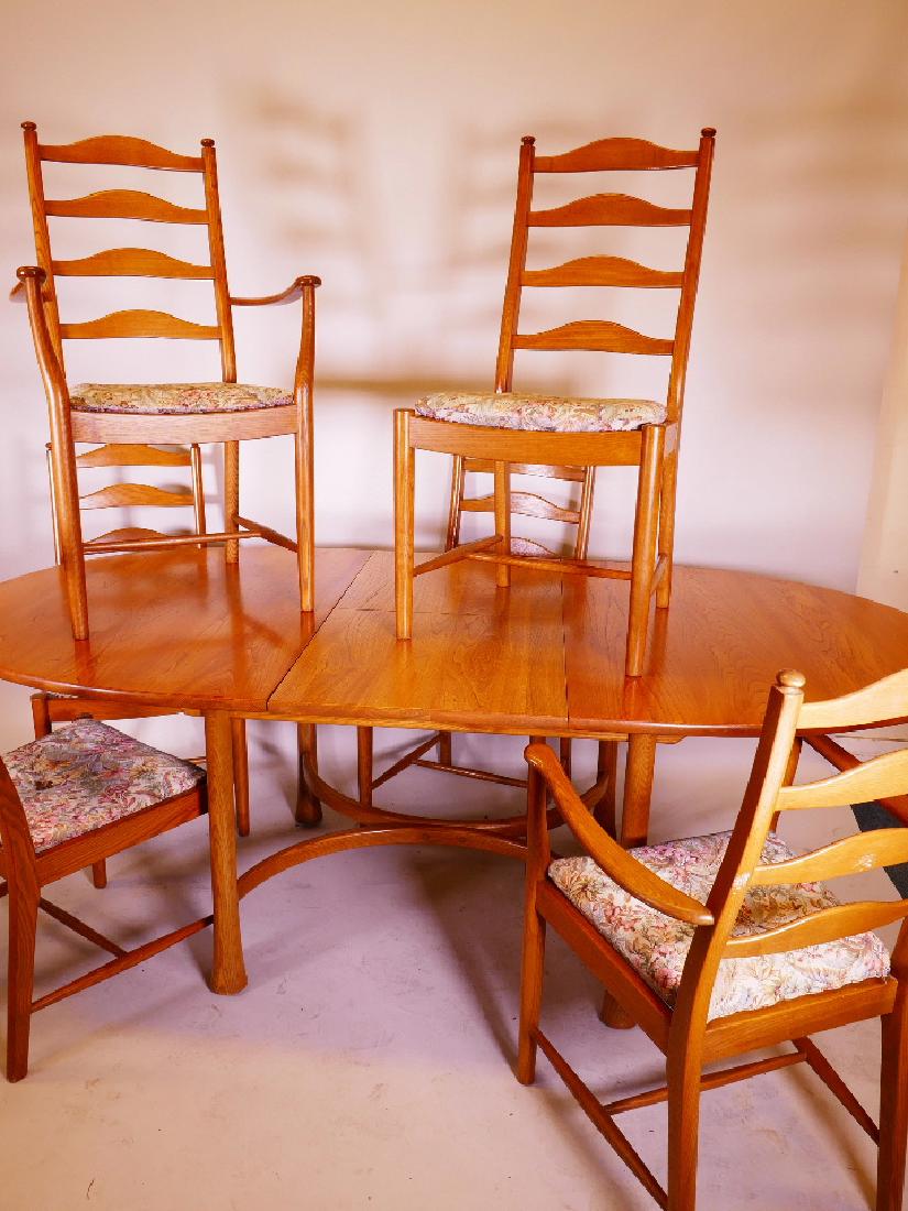 An Ercol elm dining table with fold out leaf, 64" x: An Ercol elm dining table with fold out leaf, 64" x 42", 28 3/4" high, together with six ladderback chairs, two carvers and four standard, ensuite