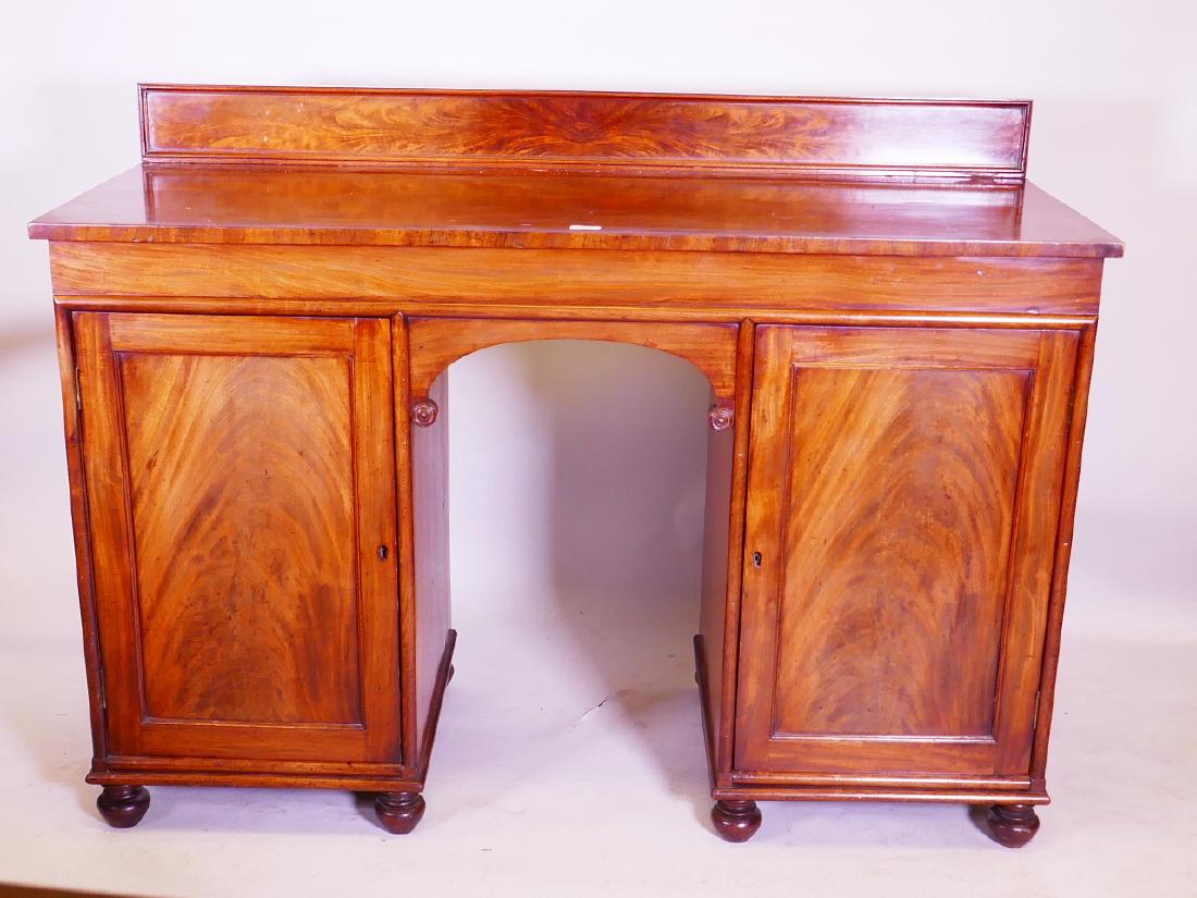 An early C19th mahogany sideboard, comprising two: An early C19th mahogany sideboard, comprising two cupboards, one fitted with a cellarette drawer, 55" x 22" x 40"