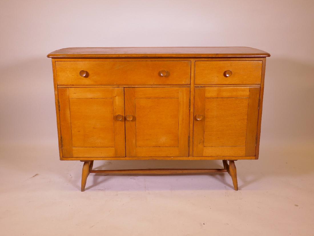 A mid C20th beech and elm topped, Ercol style sideboard: A mid C20th beech and elm topped, Ercol style sideboard with two drawers over three cupboards, raised on splay supports, 48" x 18" x 32"