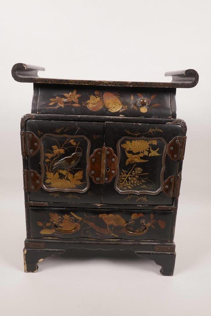 A Japanese Meiji period lacquered table cabinet of: A Japanese Meiji period lacquered table cabinet of pagoda form, the top drawer over two doors revealing six small drawers, over a single base drawer on bracket feet, with all over decoration of birds,
