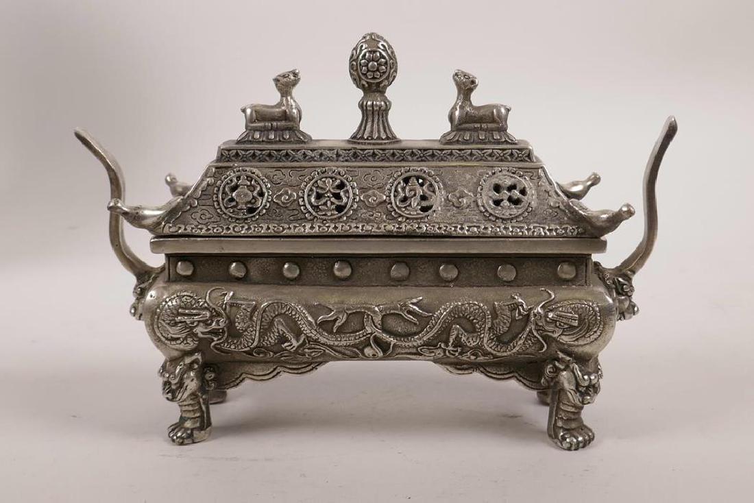 A Chinese silvered metal two handled censer raised on: A Chinese silvered metal two handled censer raised on four pawed feet, decorated with dragons to side and knops in the form of deer, impressed double vajra mark to base, 6½" x 2½"