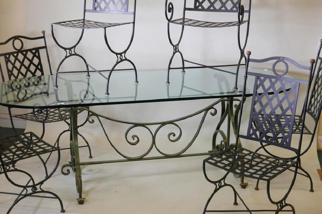 A glass topped dining table, raised on a painted: A glass topped dining table, raised on a painted wrought metal base and a set of metal chairs (four and two), 90" x 36"