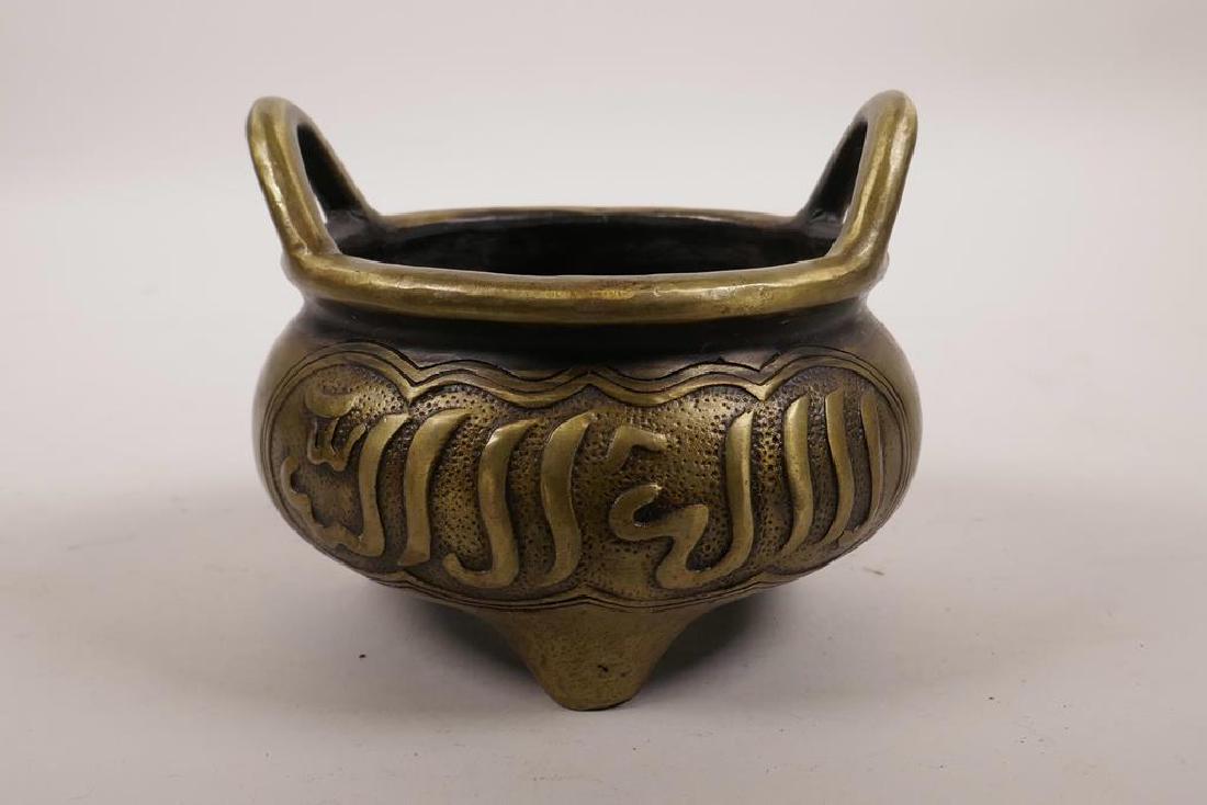 A Chinese bronze censer on tripod feet with two handles: A Chinese bronze censer on tripod feet with two handles and calligraphy decoration, impressed 6 character mark to base, 5½" diameter