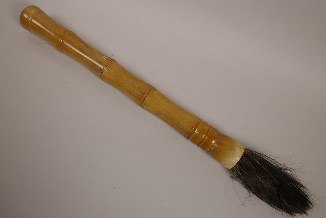 A Chinese bone handled calligraphy brush, 20½" long: A Chinese bone handled calligraphy brush, 20½" long