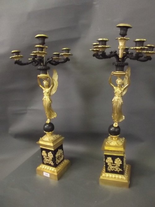 A large pair of Empire style bronze and ormolu 5 branch: A large pair of Empire style bronze and ormolu 5 branch table candelabra supported by winged figures, 28½'' high