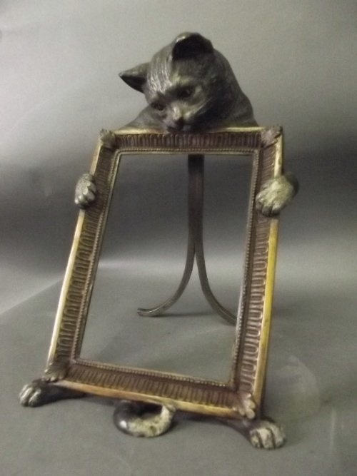 A cold painted bronze photograph frame decorated with a: A cold painted bronze photograph frame decorated with a cat to top, 10'' high