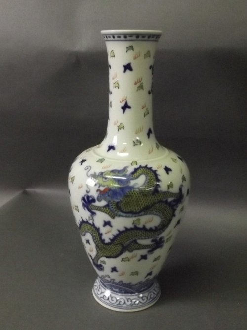 A white ground Chinese vase decorated with dragons and: A white ground Chinese vase decorated with dragons and bats, 6 character mark to base, 10'' high