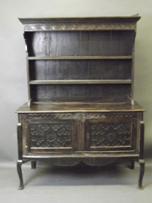 A C19th carved oak Welsh dresser with a boarded delft r: A C19th carved oak Welsh dresser with a boarded delft rack, 60'' x 23'', 80½'' high