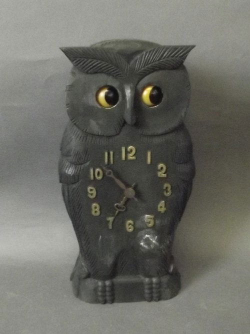 A wooden clock carved in the form of an owl with moving: A wooden clock carved in the form of an owl with moving eyes, 9¾'' high