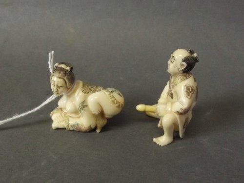 A pair of Japanese fine bone erotic interlocking: A pair of Japanese fine bone erotic interlocking netsuke figures of a man and woman in erotic pose, signed to back, 1¾'' high