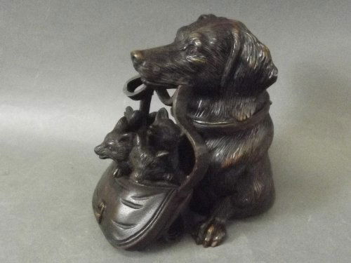 A Black Forest style carved figure of a dog carrying: A Black Forest style carved figure of a dog carrying fox cubs in a bag, 5'' high