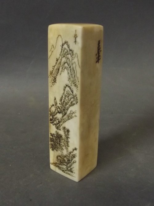 A Chinese soapstone seal decorated with an engraved: A Chinese soapstone seal decorated with an engraved mountainous landscape, 3½'' long