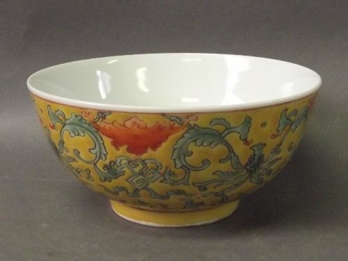 A Chinese yellow ground porcelain bowl painted with: A Chinese yellow ground porcelain bowl painted with stylized bats and trailing flowers, seal mark to base, 5½'' diameter