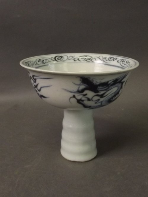 A Chinese blue and white stem cup decorated with: A Chinese blue and white stem cup decorated with flowers inside and dragons outside, 3½'' high