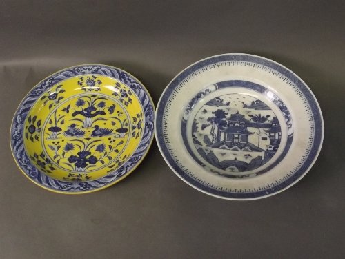 Two Chinese blue and white dishes, one yellow ground: Two Chinese blue and white dishes, one yellow ground with water fowl decoration and 6 character mark to base, 9¼'' diameter, the other with pagoda decoration, 10'' diameter