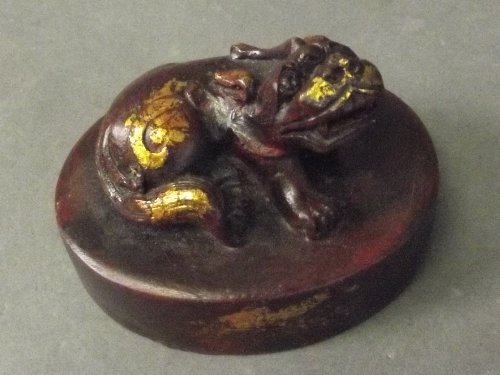 A circular Chinese seal with kylin to top picked out in: A circular Chinese seal with kylin to top picked out in gilt, 3½'' long