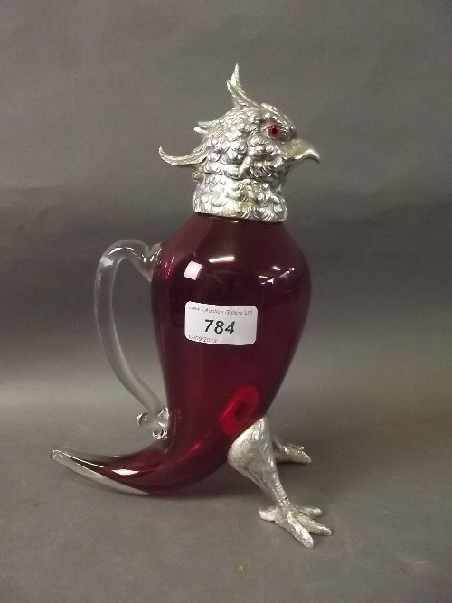 A cranberry glass and silver plate claret jug in the: A cranberry glass and silver plate claret jug in the form of a cockatoo, 10'' high