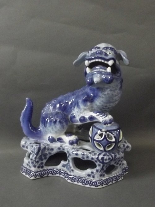 A blue and white Delft Fo dog decorated with flowers,: A blue and white Delft Fo dog decorated with flowers, markings to base, 10'' high