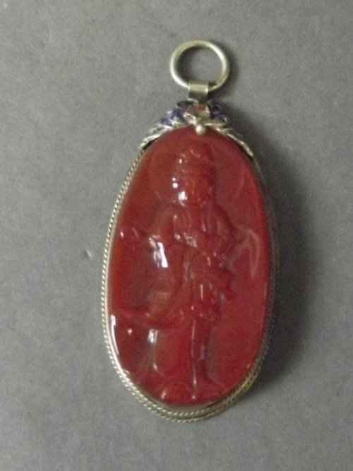 A Chinese composition pendant depicting a goddess: A Chinese composition pendant depicting a goddess mounted on a brass backing, character stamp to back, 3'' long, Best Bid