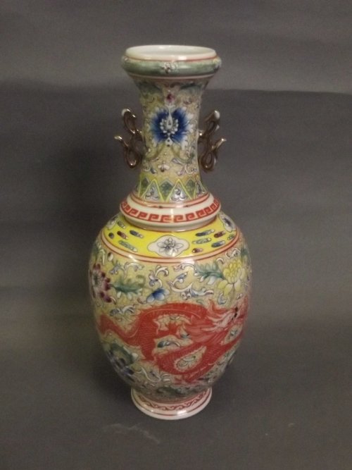 A Chinese polychrome enamel vase decorated with dragons: A Chinese polychrome enamel vase decorated with dragons amongst flowers to sides, with twin gilt handles, stamp mark to base, 10½'' high