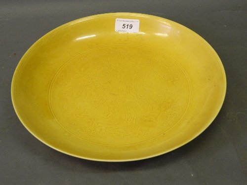 A Chinese yellow ground porcelain bowl with incised dec: A Chinese yellow ground porcelain bowl with incised decoration of dragons, seal mark to base, 10½'' diameter