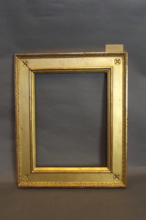 An Arts & Crafts style giltwood frame with carved corne: An Arts & Crafts style giltwood frame with carved corner roundel decoration, 15¾'' x 19''