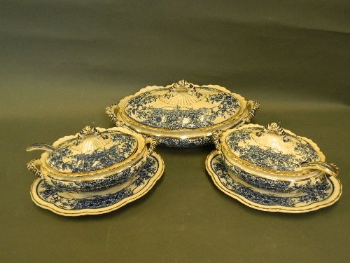 Three C19th blue and white tureens with covers and: Three C19th blue and white tureens with covers and ladles, decorated with flowers picked out in gilt, 12'' diameter