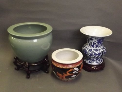 A Chinese blue and white vase on a pierced hardwood: A Chinese blue and white vase on a pierced hardwood stand with floral decoration, a celadon ground jardiniÃ¨re and stand, and one other with dragon decoration, jardiniÃ¨re 13Â¼'' high