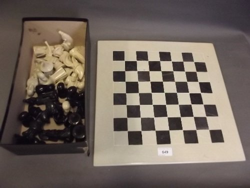 An African carved stone chess set and board, 4Â¼'' high: An African carved stone chess set and board, 4Â¼'' high