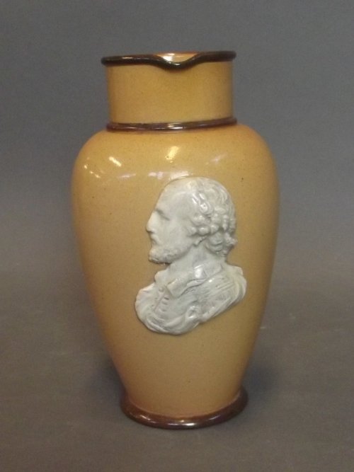 A Doulton Lambeth jug with an applied moulded head of: A Doulton Lambeth jug with an applied moulded head of Shakespeare, 7'' high