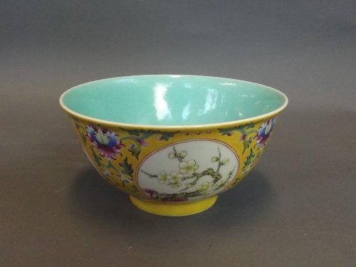 A Chinese yellow ground bowl with lotus flower patterns: A Chinese yellow ground bowl with lotus flower patterns and 4 floral decorative panels, marked to base, 6¼'' diameter