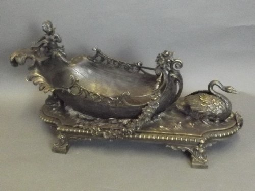 A large bronze centrepiece in the form of a leaf boat: A large bronze centrepiece in the form of a leaf boat pulled by a swan, 22'' long
