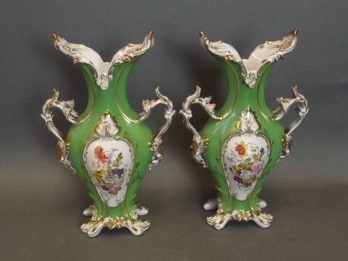 A pair of Coalbrookdale style green ground ornate: A pair of Coalbrookdale style green ground ornate pottery twin handled vases with painted floral arrangement decoration picked out in gilt, 12½'' high