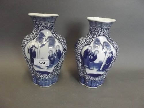 A pair of Chinese blue and shaped white pottery vases: A pair of Chinese blue and shaped white pottery vases painted with figures in a garden, 4 character mark, 7¾'' high