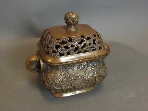 A Chinese pierced bronze censer with twin shaped: A Chinese pierced bronze censer with twin shaped elephant head handles and raised flowering tree decoration, impressed mark to base, 6¾'' x 6''