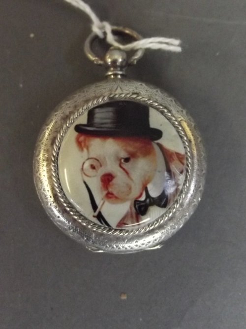 A Continental silver fob watch with applied enamel: A Continental silver fob watch with applied enamel plaque of a smoking dog wearing a hat, 1½'' diameter