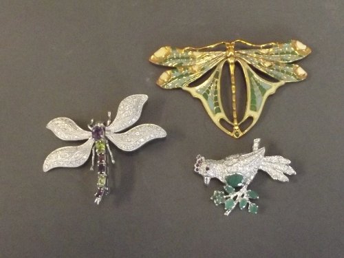 Two silver, amethyst and emerald set bird and dragonfly: Two silver, amethyst and emerald set bird and dragonfly brooches, and an enamelled metal dragonfly brooch