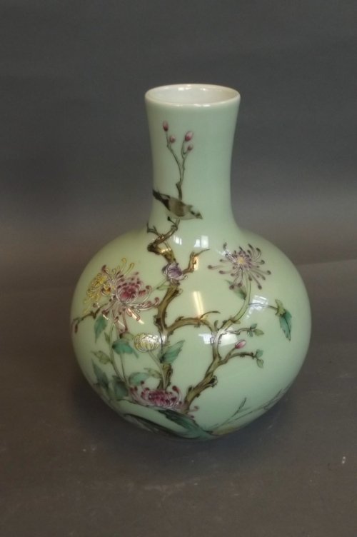 A Chinese celadon ground porcelain vase with polychrome: A Chinese celadon ground porcelain vase with polychrome enamel decoration of a bird in a flowering tree, stamped to base, 8'' high