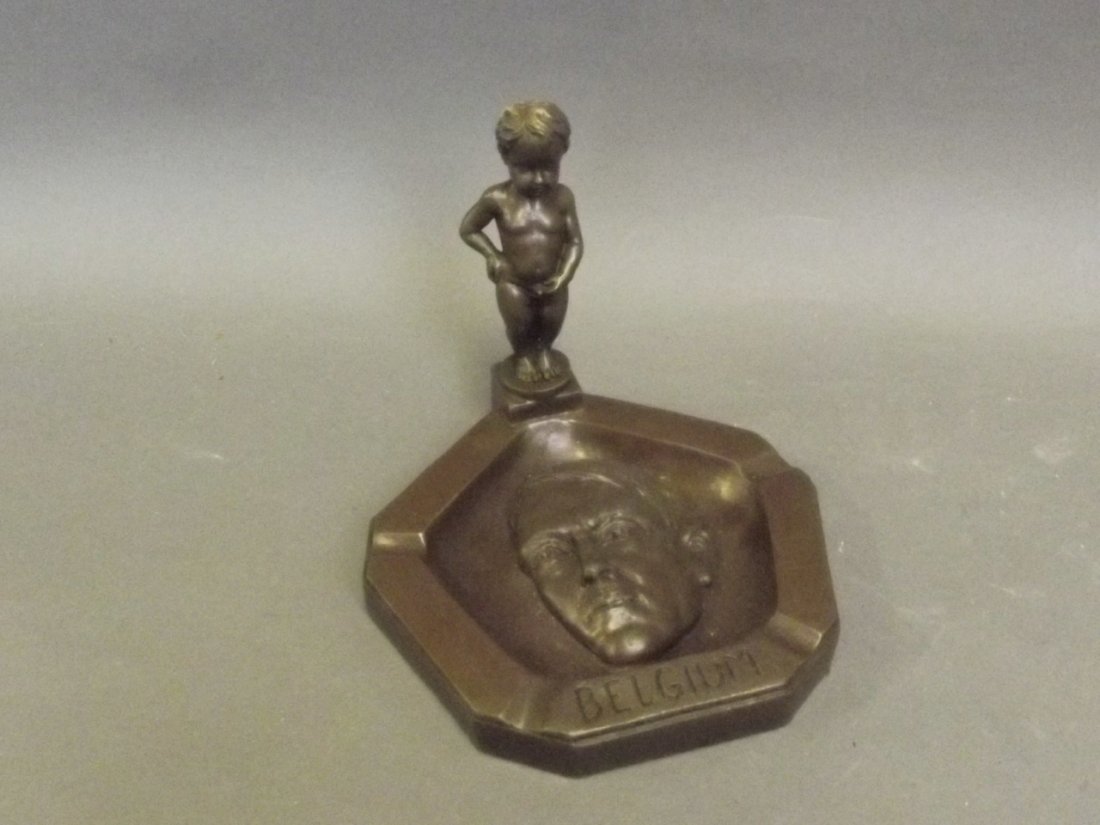 A bronze ash tray in the form of a boy urinating on: A bronze ash tray in the form of a boy urinating on Hitler's face, engraved Belgium, impressed JB verso, 5½'' high